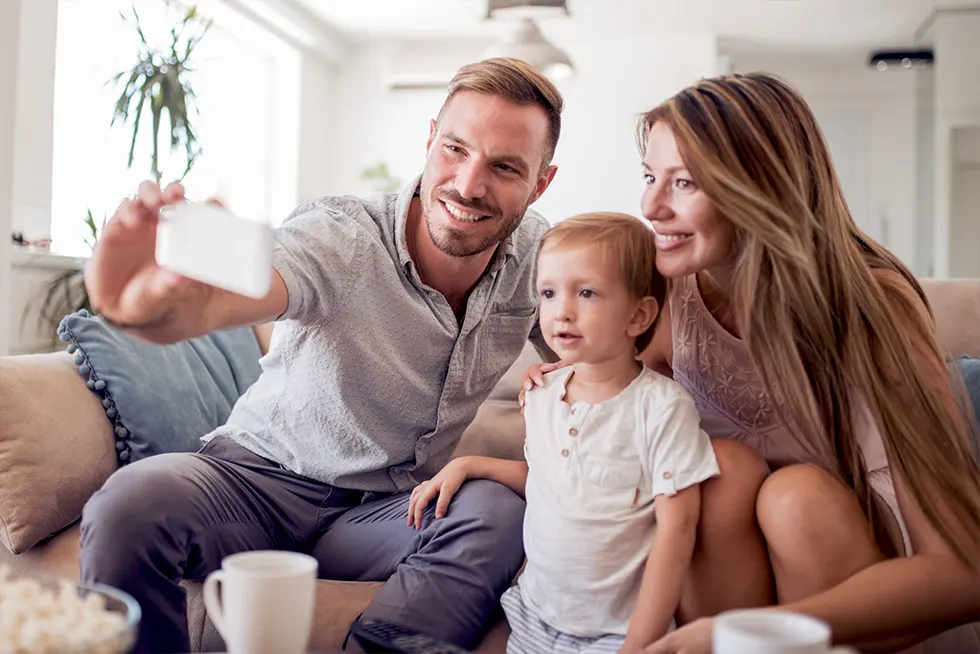 Happy family taking selfie on couch